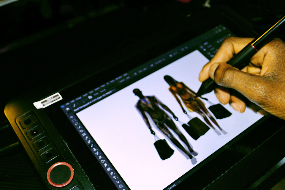 Šhema using a stylus on a digital drawing tablet working on "Retail Therapy" for "The War Within : breaking out of perdition".